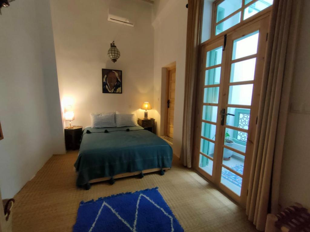 a bedroom with a bed and a large window at La Maison des Amis in Fès