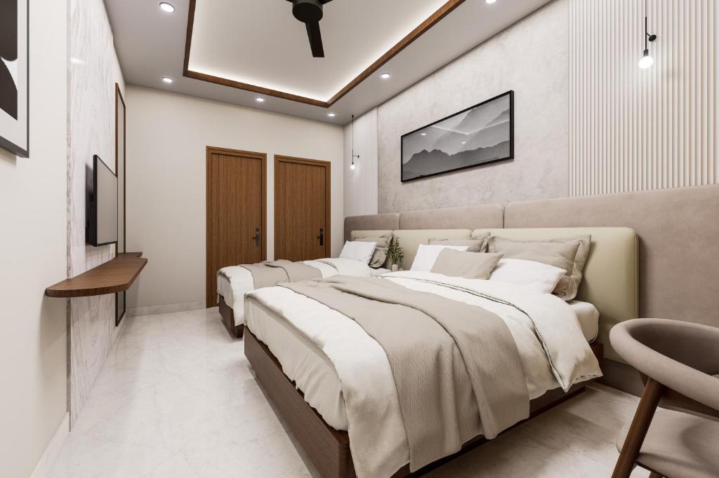 een slaapkamer met vier bedden en een tv aan de muur bij Hotel Liora Suites in Bangalore