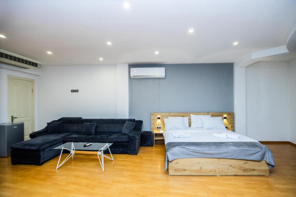 een slaapkamer met een bed en een bank bij Friendly Hotel Yerevan in Jerevan