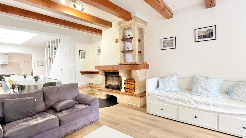 a living room with a couch and a fireplace at La Maison des Poutres & Lumières - Emile Zola in Croix