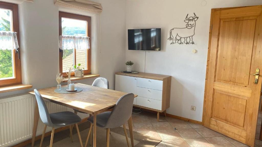 ein Esszimmer mit Tisch und Stühlen und einem Fernseher in der Unterkunft Ferienhof Heufelder Hof in Wüstensachsen
