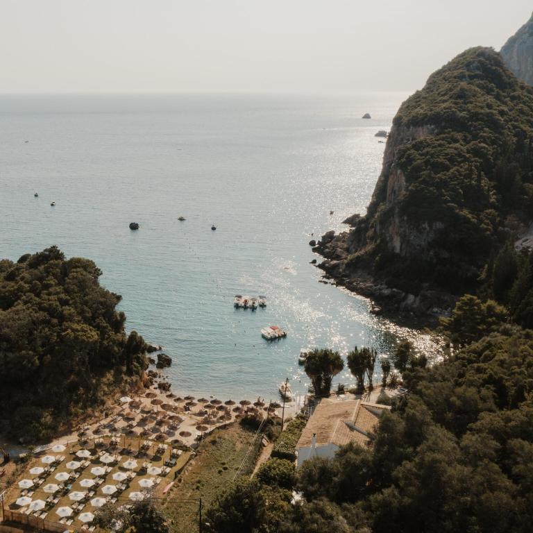 an aerial view of a beach with umbrellas at Ampelaki Blue in Paleokastritsa
