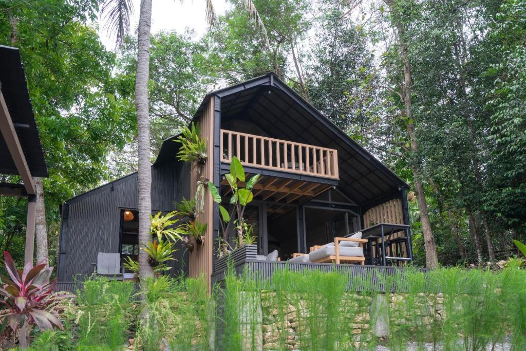 een huis in het bos met een zwart dak bij Mila Villa in Ngingas