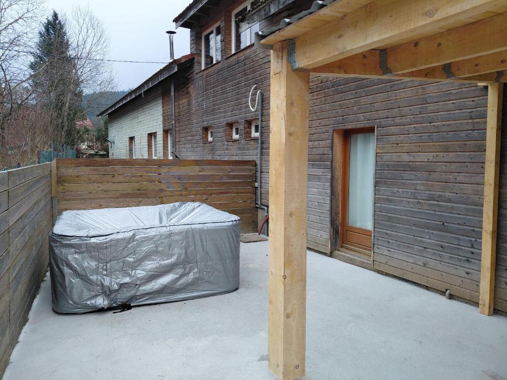 un patio avec une couverture sur le côté d'une maison dans l'établissement JACUZZI PRIVE Romann 1, à Xonrupt-Longemer