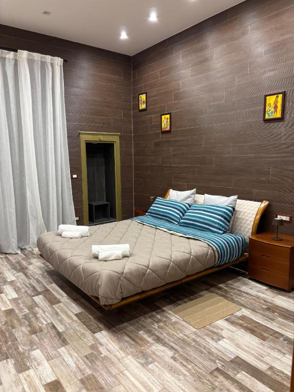 a bedroom with a large bed with blue and white pillows at La Casa del Caribe in Mola di Bari