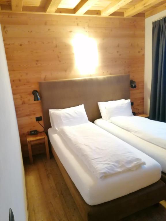 twee bedden in een kamer met houten wanden bij Chalet Noemi in Livigno