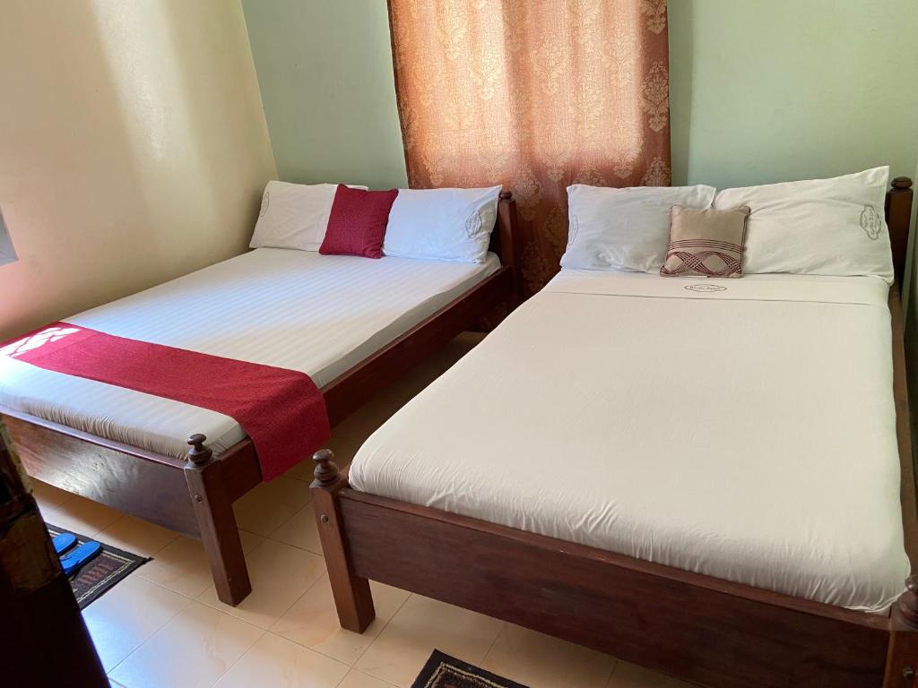 two beds in a small room withacers at Karmo Suites in Mombasa