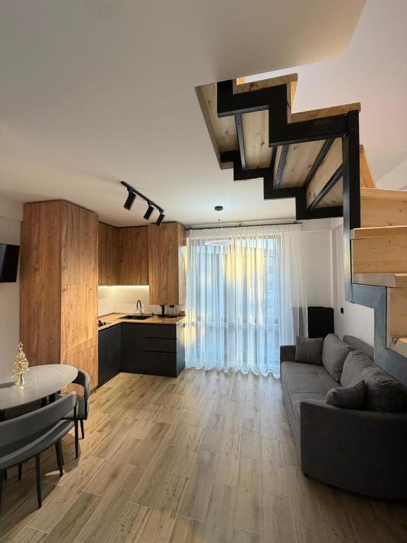 a living room with a couch and a table and a kitchen at 10 minutes from skiing in Bakuriani