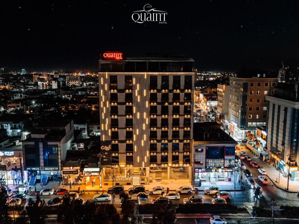 een verlicht gebouw met een bord erop bij Quaint Hotel Erbil in Erbil