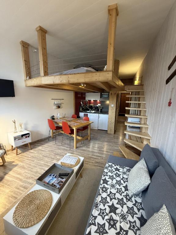 a living room with a loft bed and a table at Studio duplex hyper centre 4 personnes in Le Lioran