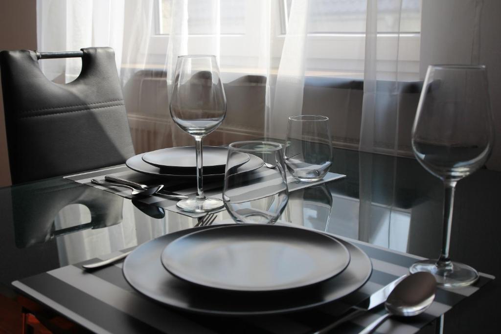 uma mesa com dois pratos e dois copos de vinho em M&M Centrum Apartments em Poznań