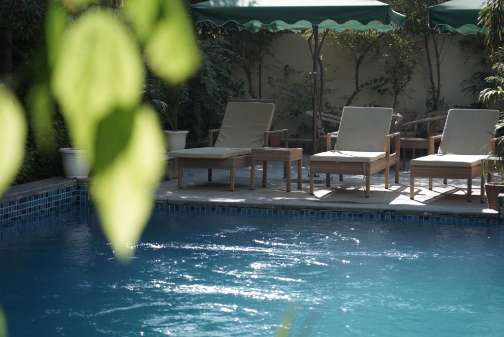 a row of chairs sitting next to a swimming pool at Ramat Niwas By Kutani Stays in Jaipur