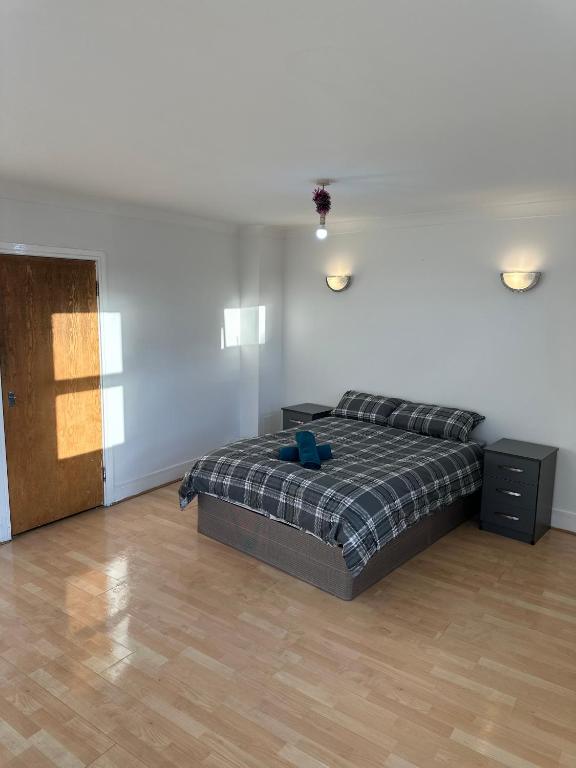 a bedroom with a bed and a wooden floor at Stunning Apartments Central Croydon in Croydon