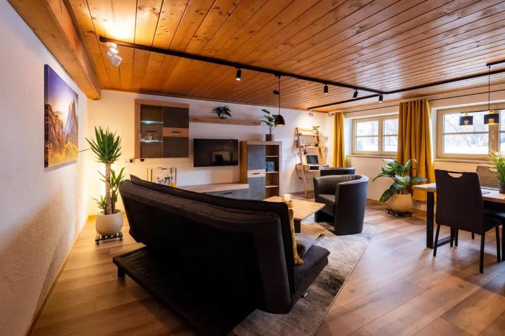 een woonkamer met een bank en een eetkamer bij Ferienwohnung Hans - Hohenpeißenberg mit Gartenblick in Hohenpeißenberg