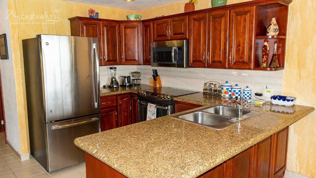 una cucina con mobili in legno e un frigorifero in acciaio inossidabile di Sonoran Spa W403 a Campo del Medio