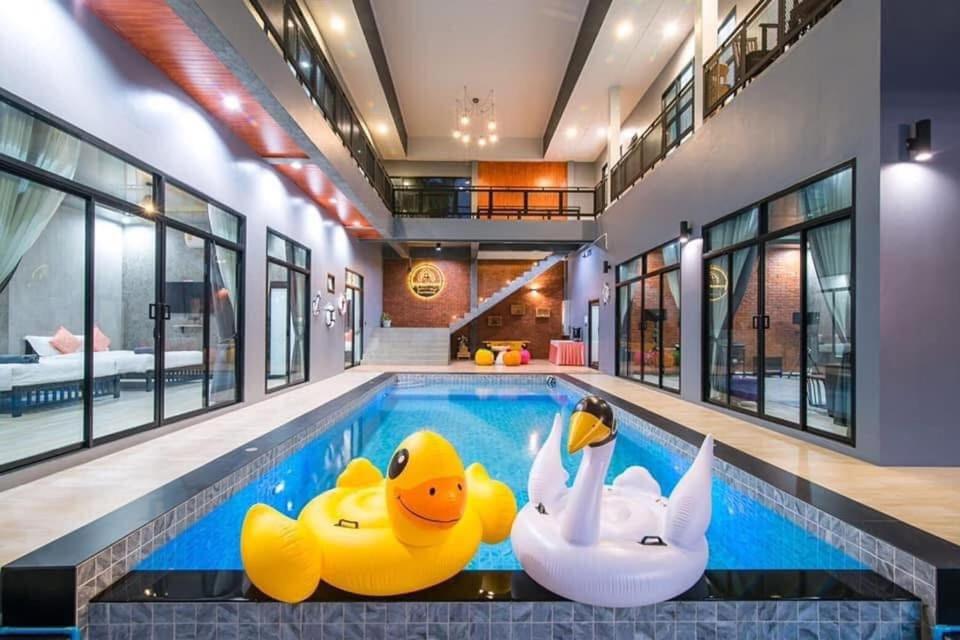 a pool with three rubber ducks in a house at บ้านบรรยากาศ พูลวิลล่าชะอำ in Ban Bo Prakhon