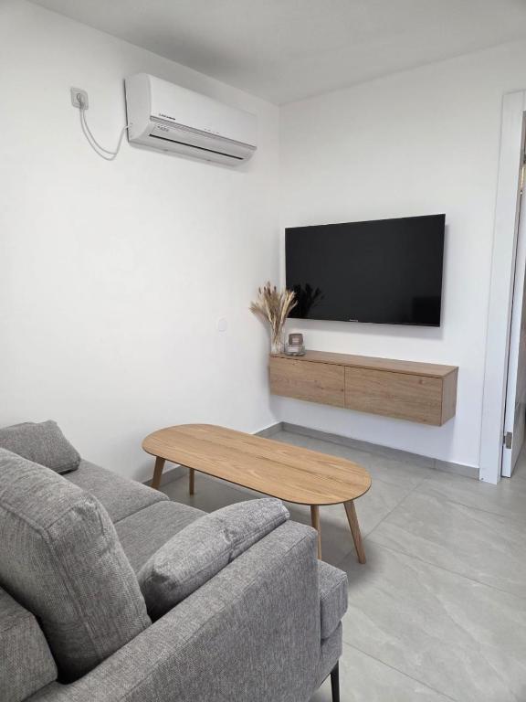 a living room with a couch and a tv at Atalya Suite in Eilat