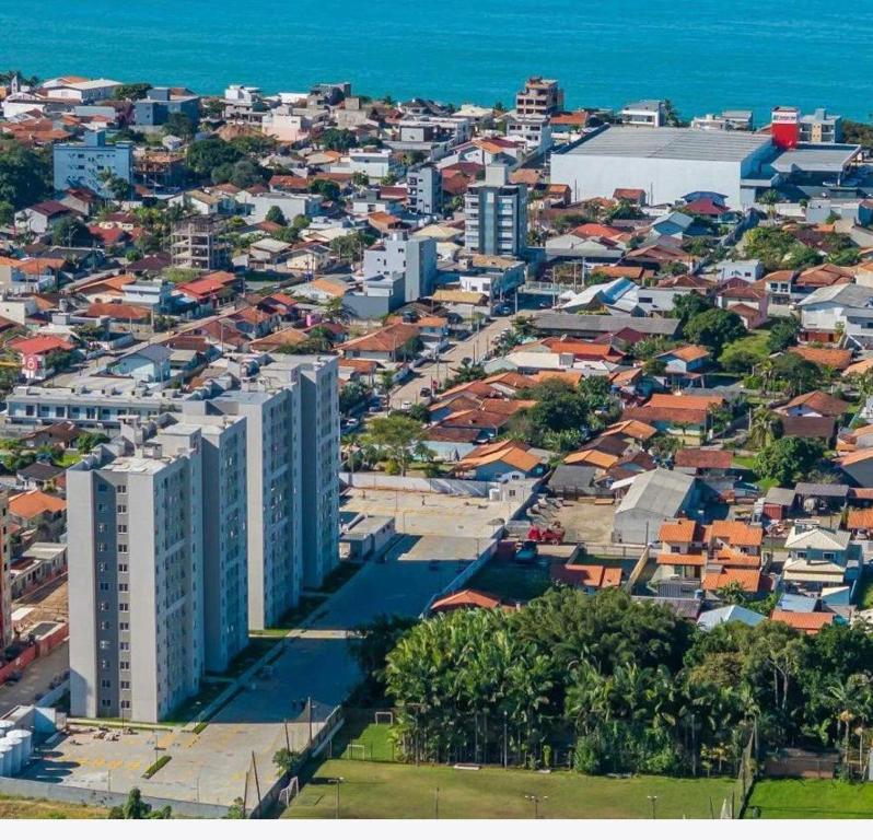 - une vue aérienne sur une ville avec des bâtiments et l'océan dans l'établissement Modern Apartment 500m from Beach, à Barra Velha