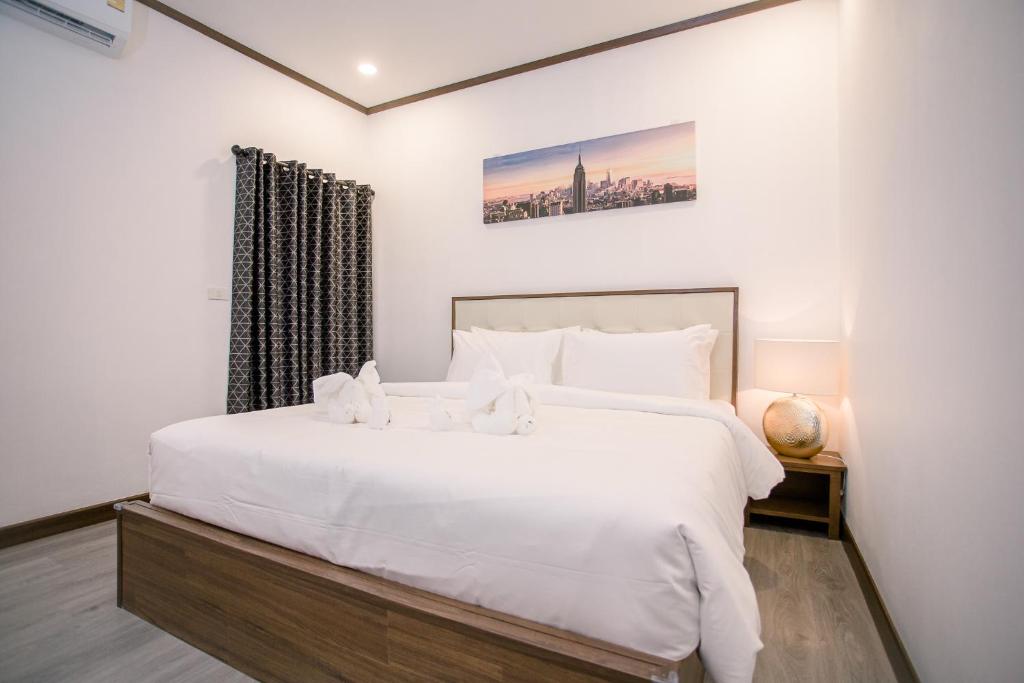 ein Schlafzimmer mit einem großen weißen Bett und einem Fenster in der Unterkunft De Thaphae Chiangmai in Chiang Mai