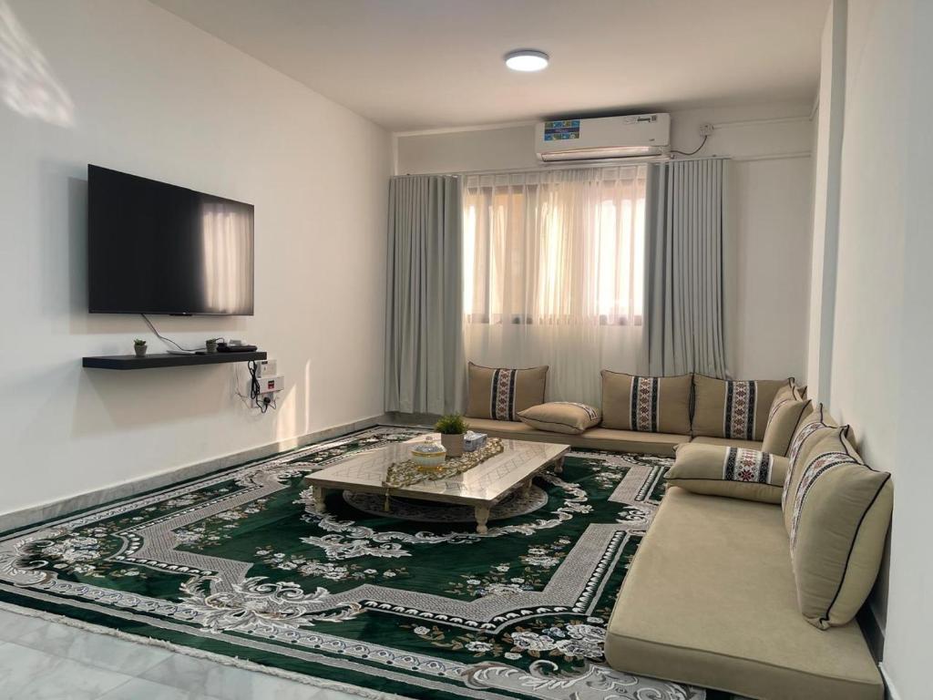 ein Wohnzimmer mit Sofa und Tisch in der Unterkunft Furnished 2BR Central Al Ain in al-Ain