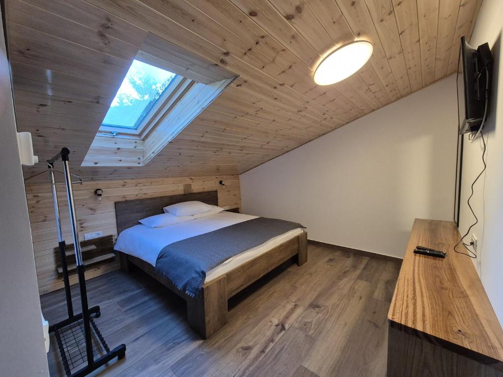 a bedroom with a bed in a room with a window at Gray River Resort in Obarsia-Lotrului