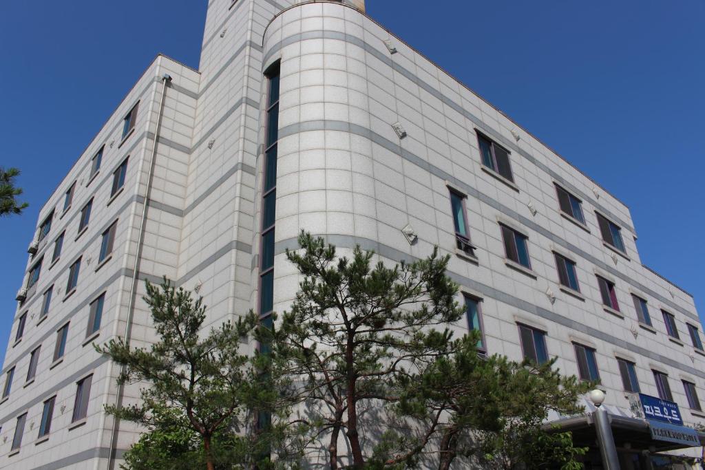 um edifício branco com árvores em frente em Hotel Parkwood Incheon Airport em Incheon
