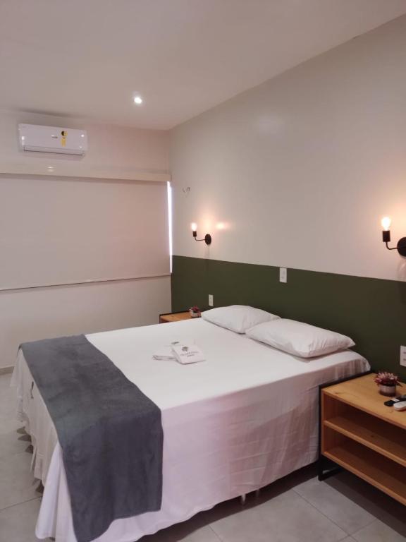 a bedroom with a large white bed and a table at Pousada Primavera in Parnaíba