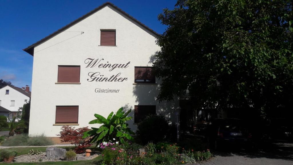 ein weißes Gebäude mit einem Schild an der Seite in der Unterkunft Weingut Günther und Gästezimmer 