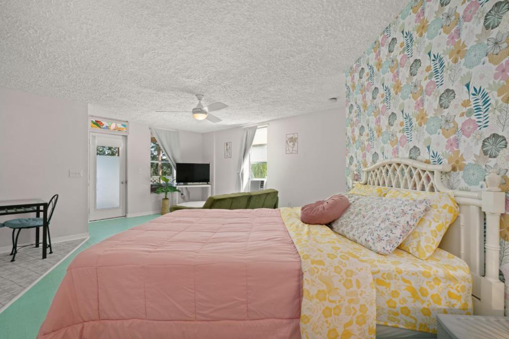 ein Schlafzimmer mit einem großen Bett mit einer rosa Tagesdecke in der Unterkunft Sebring Circle Studio Stay- Postcard Mural Views in Sebring