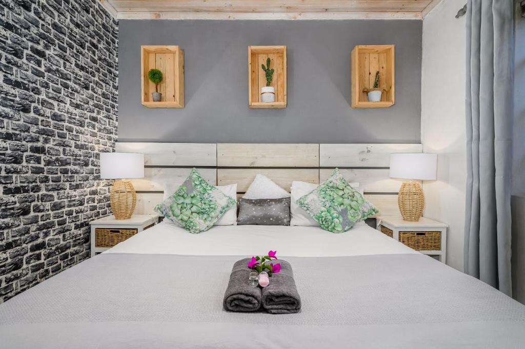 ein Schlafzimmer mit einem weißen Bett mit Blumen darauf in der Unterkunft 302 On Old Sea View Road Chelsea in Port Elizabeth