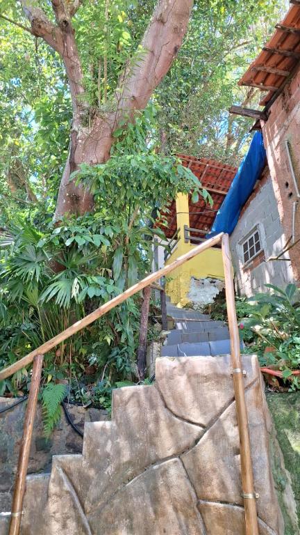 una rampa di scale che conduce a una casa con un albero di Pousada Três Irmãos a Parati