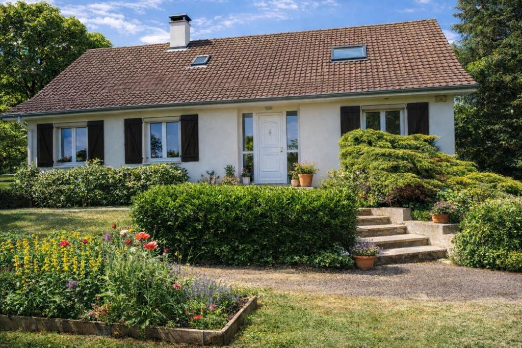 een klein wit huis met bloemen in de tuin bij Maison d'Hôtes de Belleville in Belleville