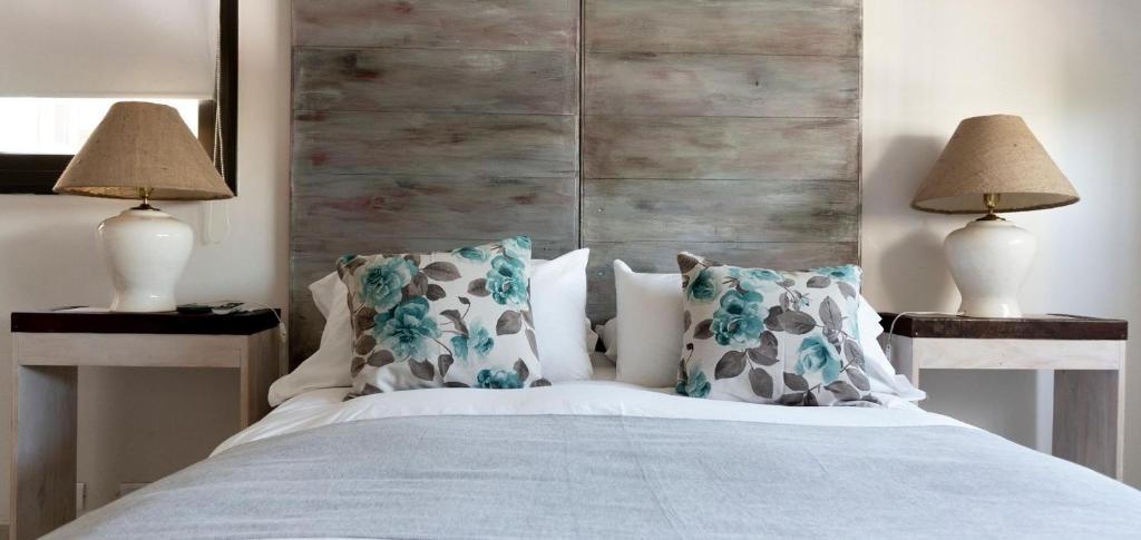 ein Schlafzimmer mit einem weißen Bett mit Kissen und 2 Lampen in der Unterkunft Hotel Internacional in Mendoza