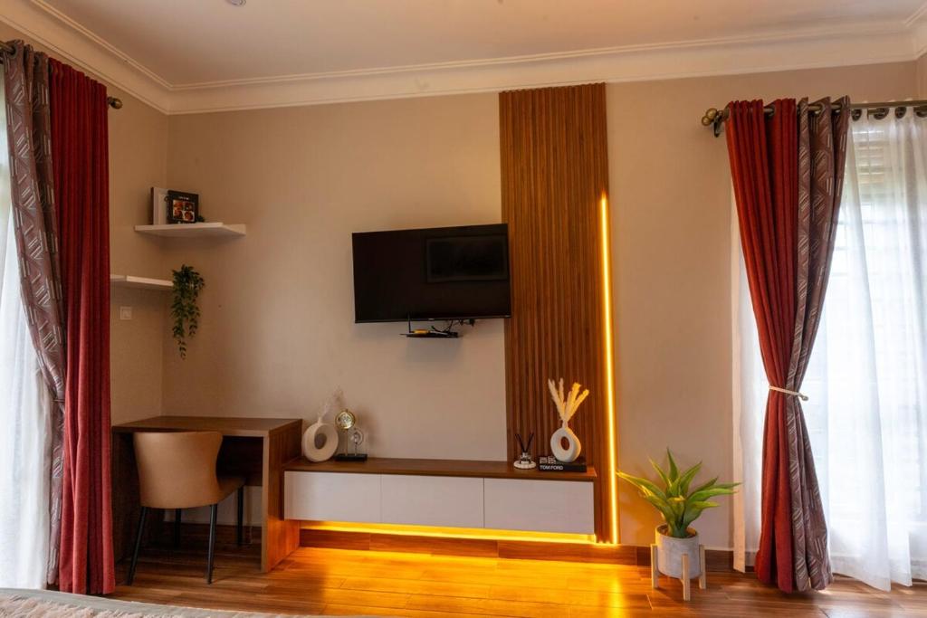 a living room with a television on the wall at Mivida Residences in Bulindo