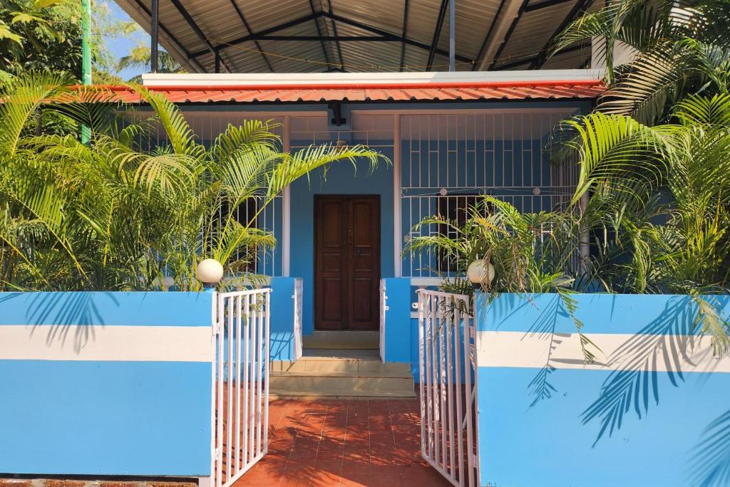 a blue house with palm trees in front of it at Florin Studio in Vagator