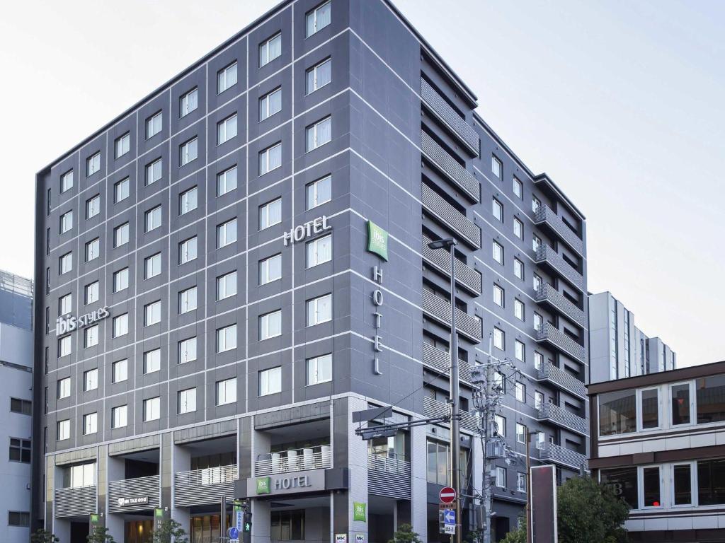a large gray building with a hotel sign on it at ibis Styles Kyoto Station in Kyoto