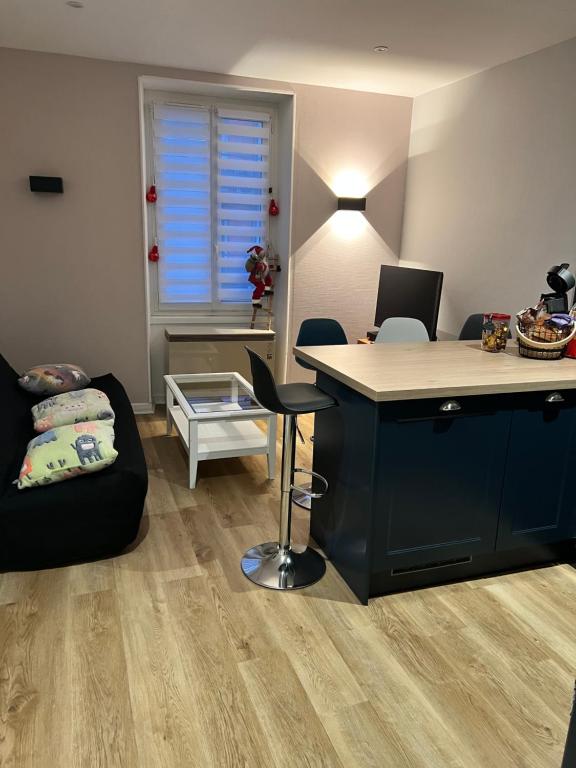 een woonkamer met een bureau en een bank bij Confort appart in Oyonnax