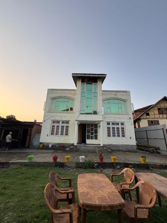 a table and chairs in front of a house at The Atiq Stay in Jāmb