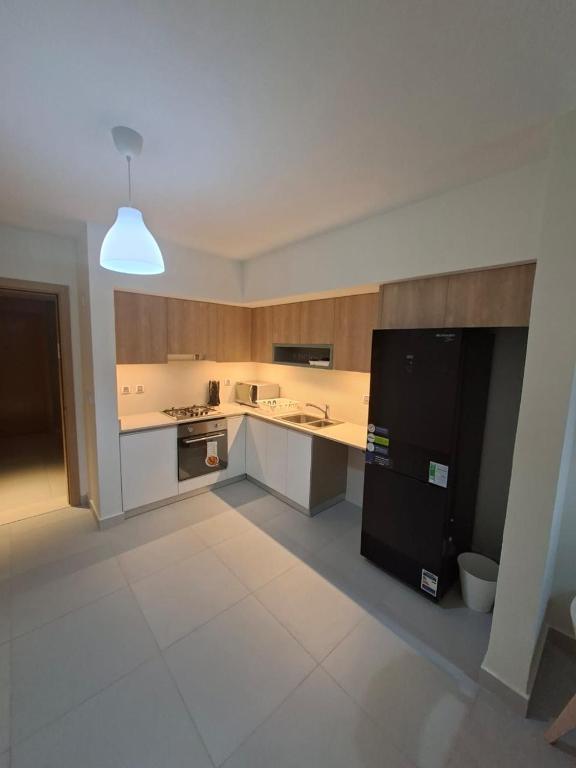 a large kitchen with a black and white refrigerator at مراسي in Sīdī ‘Abd ar Raḩmān