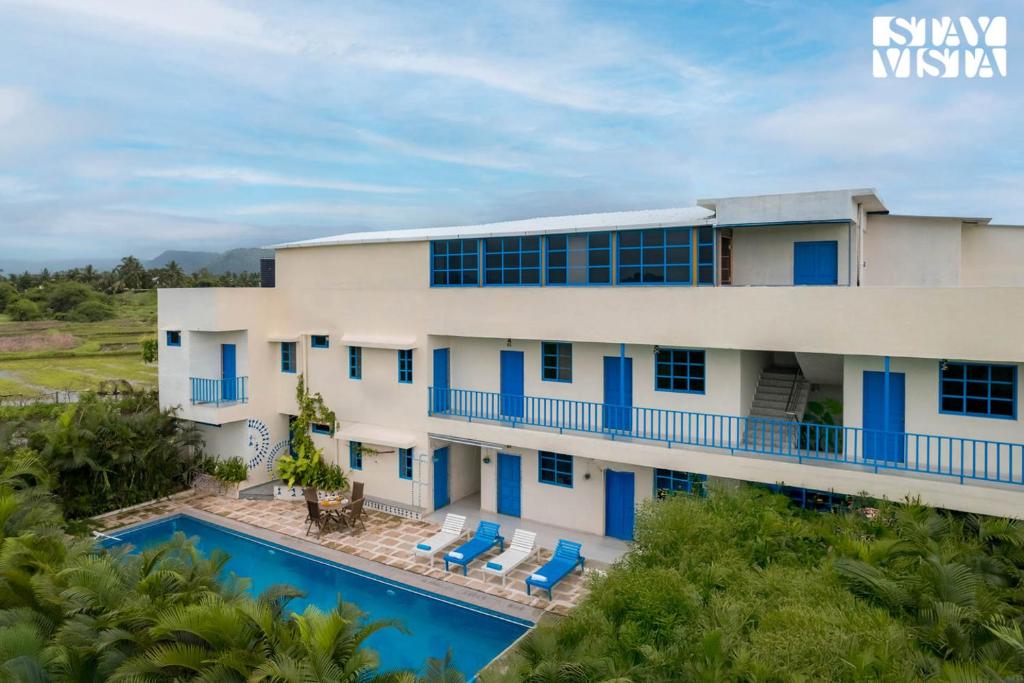 une vue aérienne d'un immeuble avec piscine dans l'établissement StayVista at Thalassa Near The Beach, à Alibaug