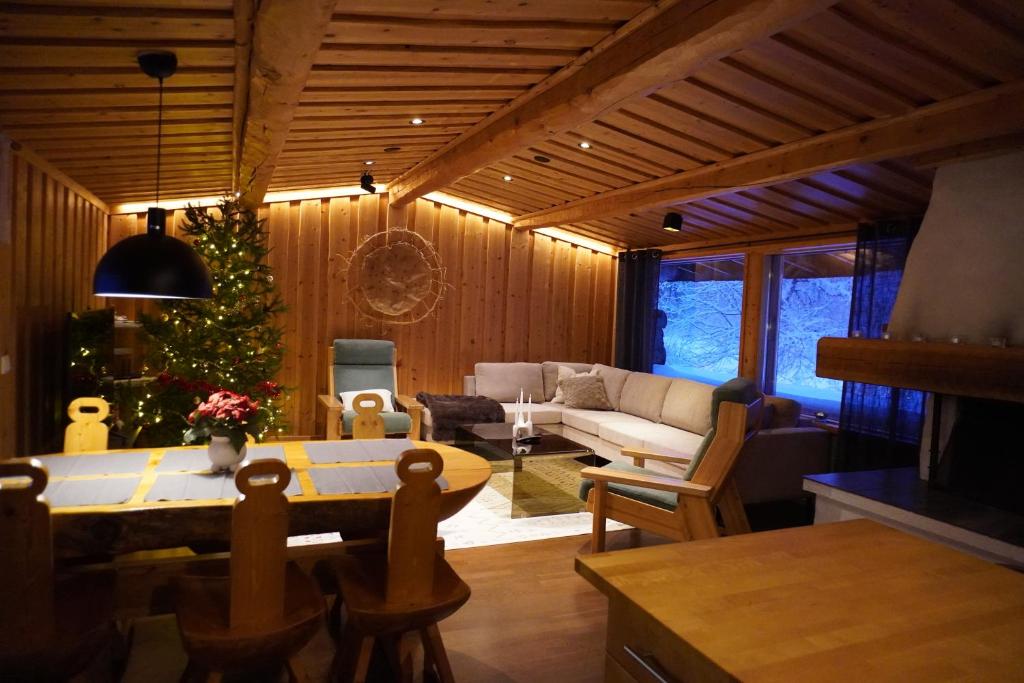 a living room with a christmas tree and a couch at Private log villa by the Ivalo River in Ivalo