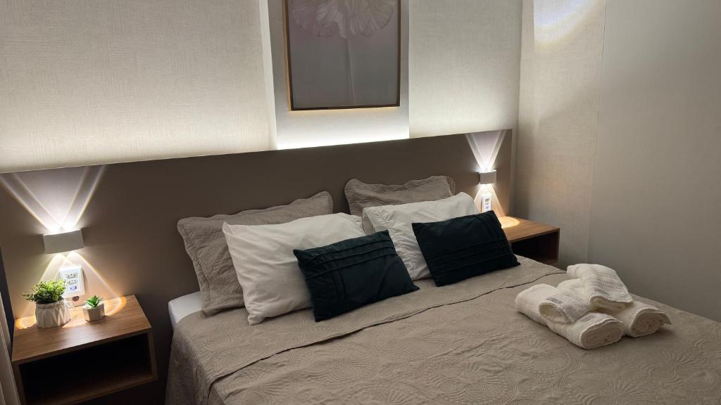 ein Schlafzimmer mit einem großen Bett mit zwei Nachttischen in der Unterkunft Apto novo perto da UFF e Plaza in Niterói