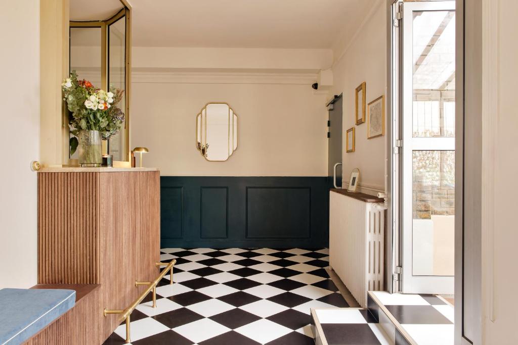a bathroom with a black and white checkered floor at Hôtel de la Comète in Paris