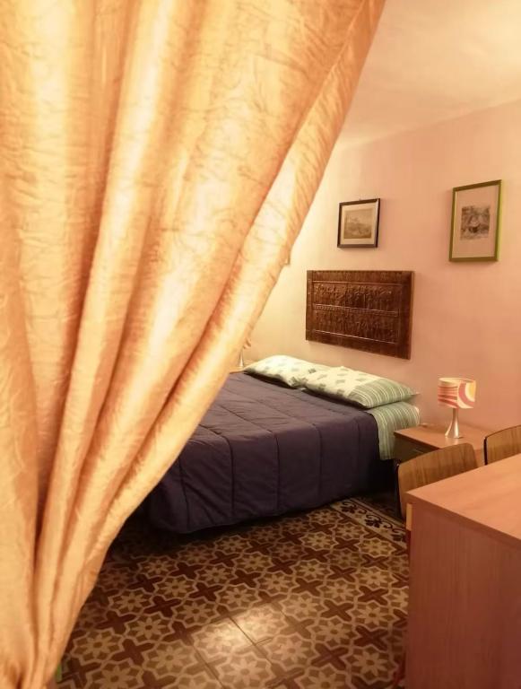 a bedroom with a bed and a curtain at Tomicla in Monreale