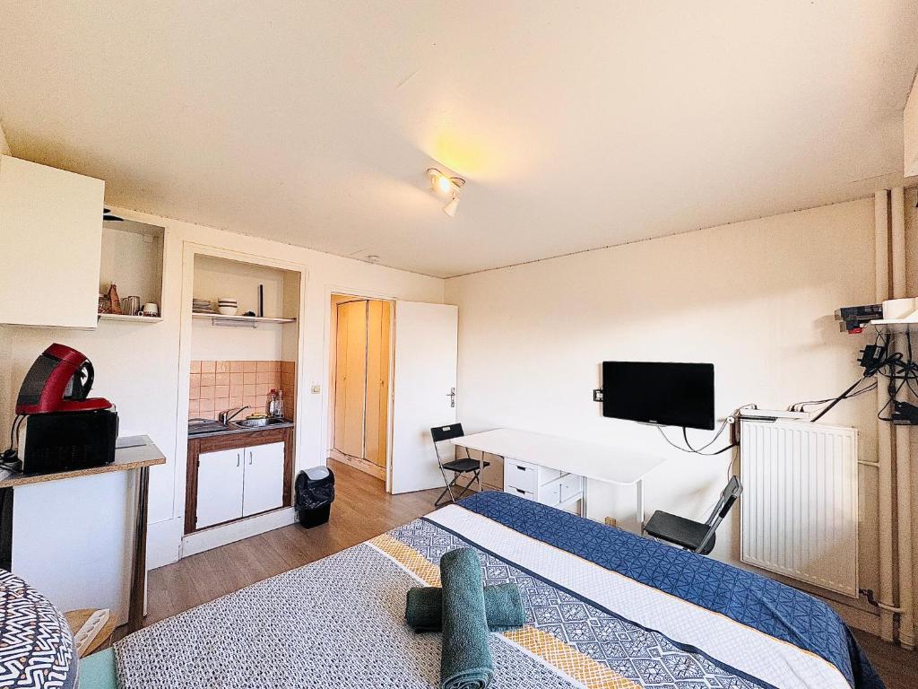 ein Schlafzimmer mit einem Bett und einem Schreibtisch mit einem Computer in der Unterkunft Studio pour 2 près de la gare in Melun