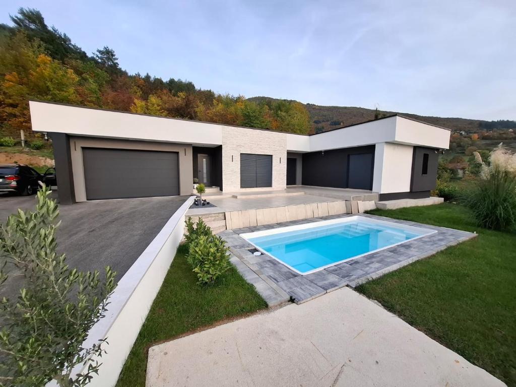 ein Haus mit einem Swimmingpool im Hof in der Unterkunft Villa Elmiso Sarajevo in Sarajevo