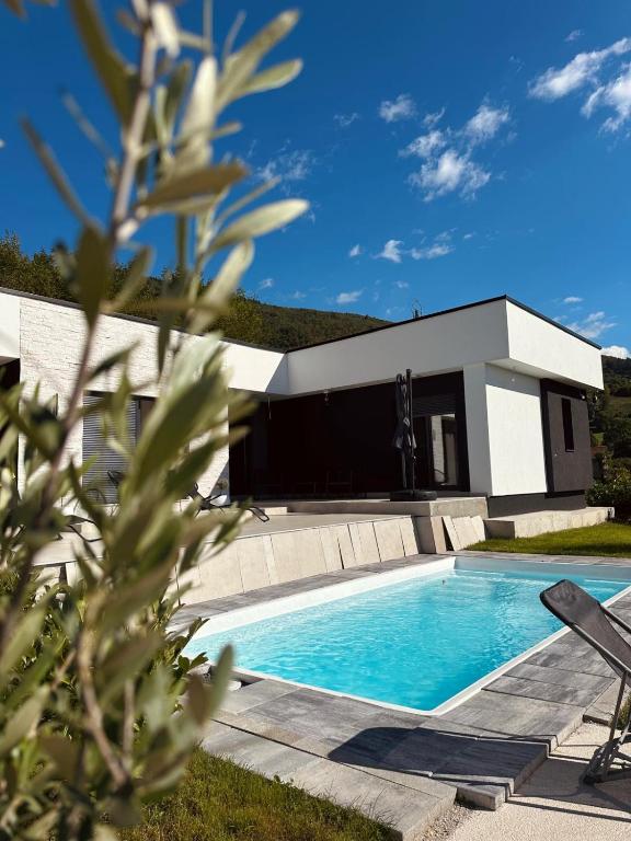 a swimming pool in front of a house at Villa Elmiso Sarajevo in Sarajevo