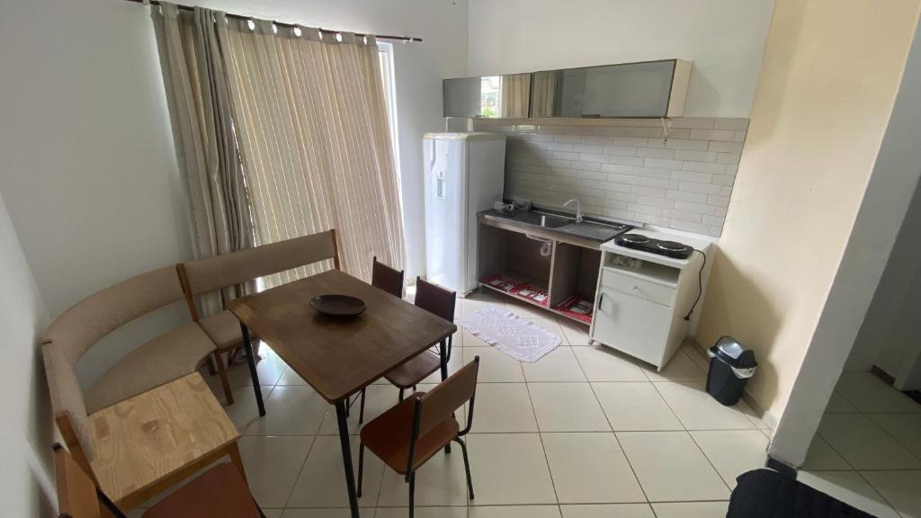 una piccola cucina con tavolo, sedie e frigorifero di Apartment in Balneário Camboriú a Balneário Camboriú