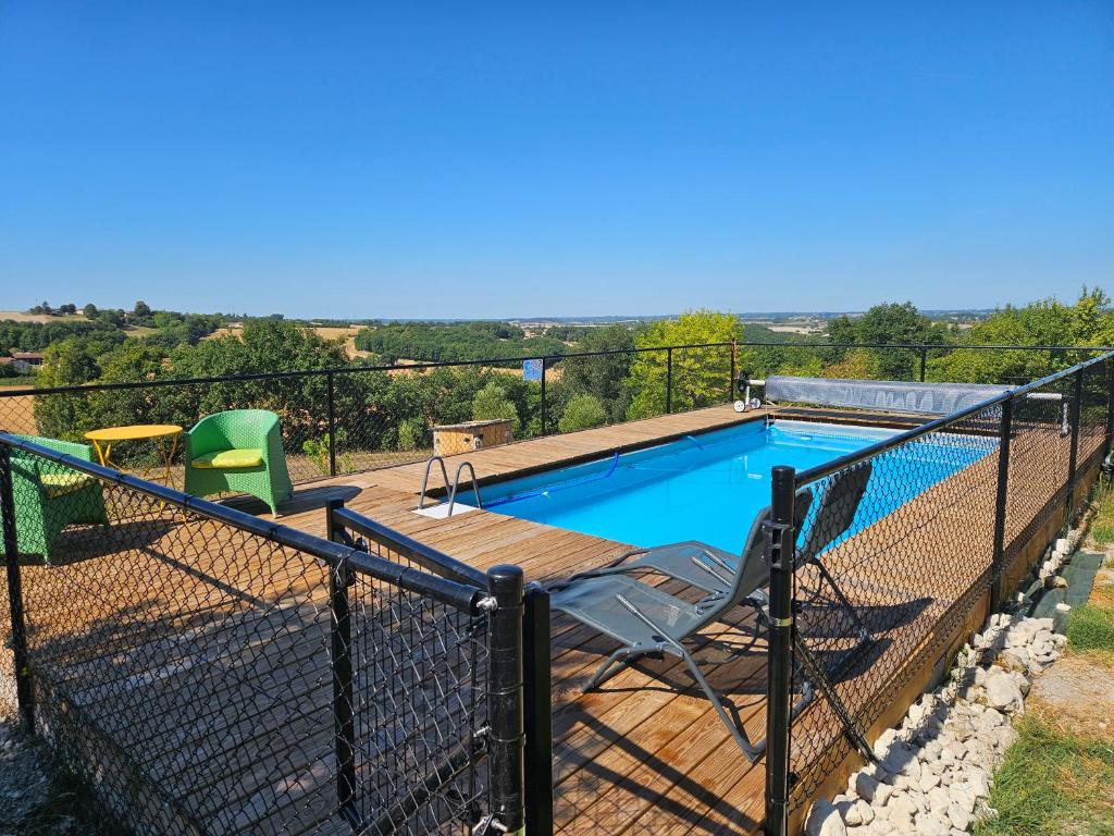a fence around a swimming pool with a table and chairs at House on the hill, near Aubeterre-sur-dronne in Saint-Romain