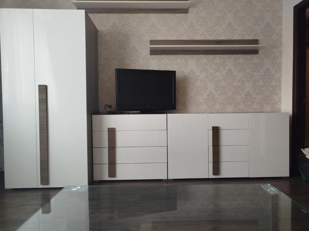 a living room with a tv and white cabinets at 1к Поділля in Vinnytsya